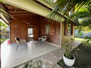 a porch of a house with chairs and a table at Coin tranquille in Sainte-Anne