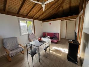 a living room with a table and chairs and a tv at Coin tranquille in Sainte-Anne