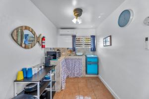 a kitchen with white walls and a blue refrigerator at Charming Studio by Sandy Beach - Affordable & Private in Rincon