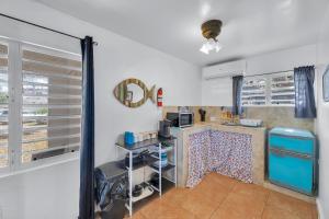 a kitchen with white walls and a blue refrigerator at Charming Studio by Sandy Beach - Affordable & Private in Rincon