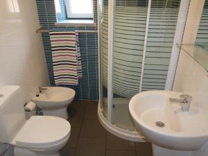 a bathroom with a toilet and a sink and a shower at Páteo dos Oliveira - Casa dos Serviçais in Évora +22 photos