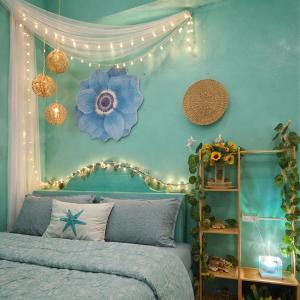 a bedroom with a blue wall with a bed and lights at Crieta Costello Homestay in San Juan