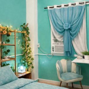 a bedroom with a bed and a window with a chair at Crieta Costello Homestay in San Juan