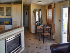 a living room with a fireplace and a table and chairs at Sea View in Trimingham