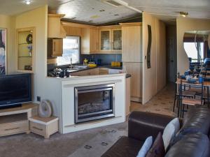 a kitchen and a living room with a fireplace at Sea View in Trimingham