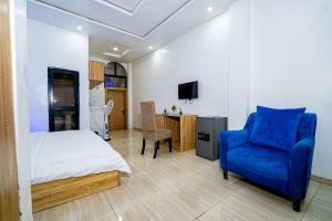 a bedroom with a bed and a blue chair at Frenezia Hotel and Apartment Ikeja GRA in Ikeja