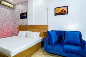a bedroom with a bed and a blue couch at Frenezia Hotel and Apartment Ikeja GRA in Ikeja +89 photos