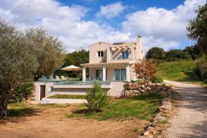 a white house on top of a hill with trees at Villa Andrionas Private Pool & Total Privacy in Corfu