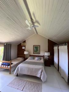 a bedroom with two beds and a ceiling fan at Pousada das Estrelas in Areal +125 photos