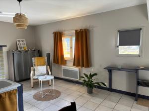 a living room with orange curtains and a chair at Gîtes Ruraux à La Ferme D'Antan in Crolles