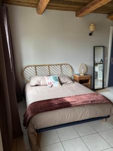 a bedroom with a large bed with a wooden headboard at Gîtes Ruraux à La Ferme D'Antan in Crolles