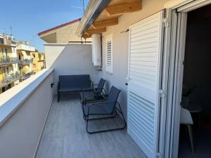 a balcony with chairs and a table on a building at La piccola Balilla in Venosa +19 photos