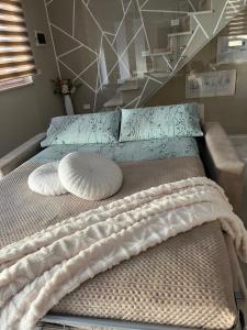 a bed with two pillows on top of it at La piccola Balilla in Venosa