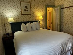 a bedroom with a large bed with white pillows at Garrison House Inn in Annapolis Royal