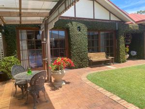 a patio with a table and chairs and a bench at Ciara's Cottage CC'S in Illawong
