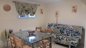 a living room with a table and a couch at Hébergement dans le vignoble du Mâconnais in Azé