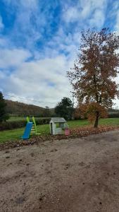 a playground with a slide and a tree and a building at Hébergement dans le vignoble du Mâconnais in Azé