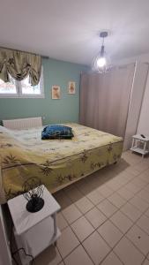 a bedroom with a bed with a yellow blanket at Hébergement dans le vignoble du Mâconnais in Azé
