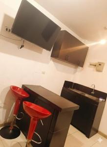 a kitchen with two red stools next to a counter at Hospedaje Dajoka's in Lima