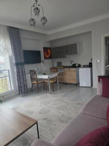 a living room with a table and a kitchen at Eşsız Manzara in Atakum