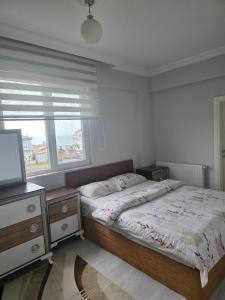 a bedroom with a bed and a window at Eşsız Manzara in Atakum