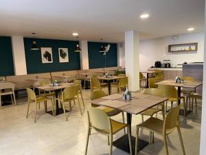 a restaurant with wooden tables and yellow chairs at Colon Plaza Hotel in Tumaco