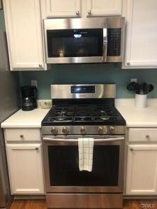 a kitchen with a stove and a microwave at The Cozy Coast Nest in Oceano