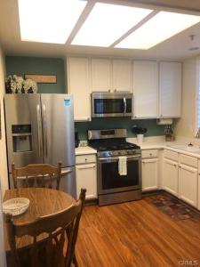 a kitchen with a stainless steel refrigerator and a table at The Cozy Coast Nest in Oceano