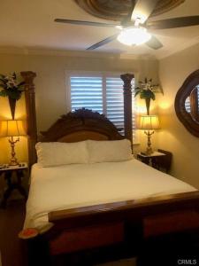 a bedroom with a bed with a ceiling fan and two lamps at The Cozy Coast Nest in Oceano