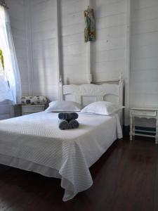 a white bed with a teddy bear sitting on it at Hospedagem Maranata in Santo André +17 photos