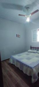 a bedroom with a bed and a ceiling fan at Excelente rancho para descansar e pescar em carlopolis in Carlópolis