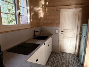 a small kitchen with a sink and a door at Staubbachbänkli in Wengen +35 photos
