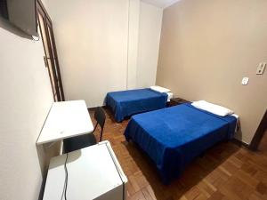 two beds in a hospital room with blue sheets at Hotel Jaú in Jaú +22 photos