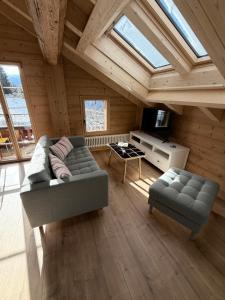 a living room with a couch and a tv at Staubbachbänkli in Wengen
