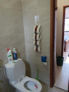 a bathroom with a toilet and towels on the wall at Studio Lac Rose in Abomey-Calavi