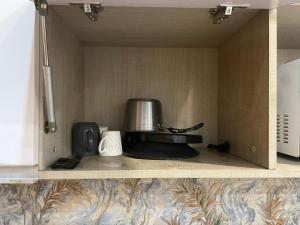a kitchen shelf with a stove and a pot at StayVerse74 in Noida +3 photos