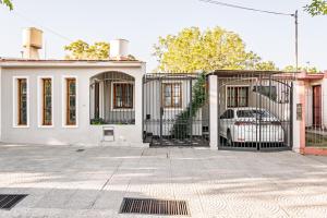 a white house with a gate with a car in it at Esencia de Montaña in El Challao
