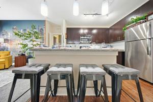 a kitchen with stools in front of a counter at Stylish 2BR w Balcony, Pool & Pet-Friendly #15 in Tampa