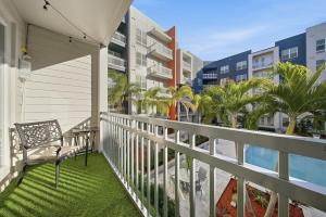 a balcony with a chair and palm trees and buildings at Stylish 2BR w Balcony, Pool & Pet-Friendly #15 in Tampa