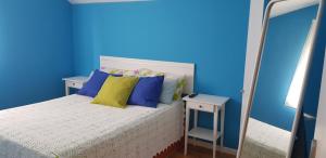 a blue bedroom with a bed and a mirror at Casa familiar katandres in San Mamés de Meruelo