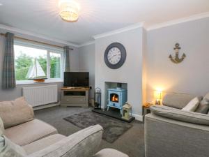 a living room with a couch and a stove at Pebbles Reach in Colwyn Bay