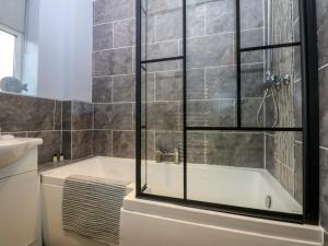 a bathroom with a tub and a toilet and a sink at Pebbles Reach in Colwyn Bay +12 photos