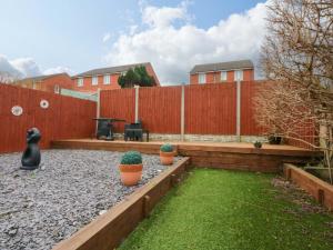 a backyard with two potted plants and a fence at Pebbles Reach in Colwyn Bay