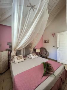 a bedroom with a large bed with pink walls at La petite kaz in Saint-François +19 photos