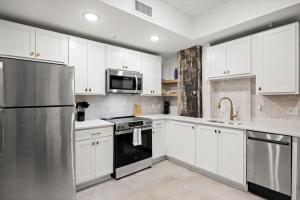 a kitchen with white cabinets and a stainless steel refrigerator at Park Hotel Studio Suite 203 in Chattanooga