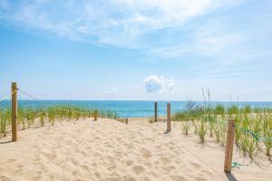 a sandy beach with the ocean in the background at Sea Sun Greetings - Kitty Hawk MP 2.5, Ocean Views, Direct Beach Access, Pool, Hot Tub, Pets OK in Kitty Hawk