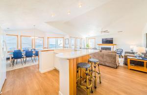 a kitchen and living room with a couch and a table at Sea Sun Greetings - Kitty Hawk MP 2.5, Ocean Views, Direct Beach Access, Pool, Hot Tub, Pets OK in Kitty Hawk +50 photos