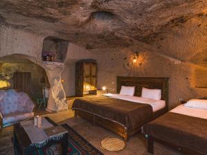 a room with two beds and a couch in a cave at Atilla's Cave Hotel in Nevşehir +23 photos