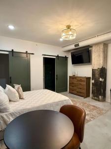 a bedroom with a bed and a table and a tv at Park Hotel Studio Suite 207 in Chattanooga