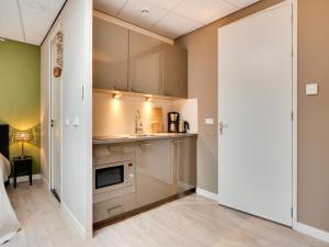 a small kitchen with a sink and a microwave at Apartment in Bergen near Schoorl Dunes in Bergen